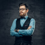 Successful bearded male with crossed arms, dressed in elegant sh